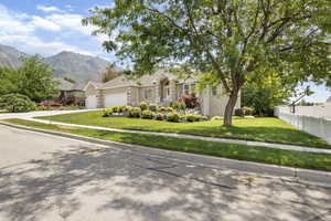 Ranch-style house with a garage, a mountain view, and a front yard