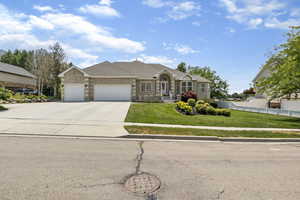 Single story home featuring a garage and a front lawn