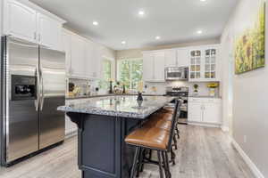 Kitchen featuring white cabinetry, stainless steel appliances, and decorative backsplash