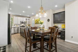 Dining space with a healthy amount of sunlight, a chandelier, and hardwood / wood-style floors