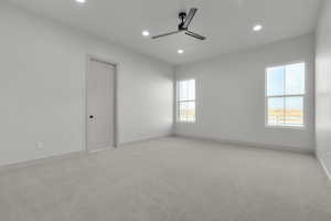 Empty room featuring ceiling fan and light colored carpet