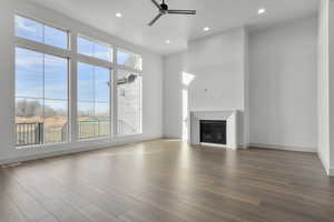 Unfurnished living room featuring wood-type flooring and ceiling fan