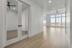 Empty room with french doors, light wood-type flooring, and ceiling fan