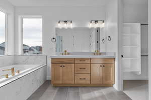 Bathroom featuring tile patterned floors, vanity, and plus walk in shower