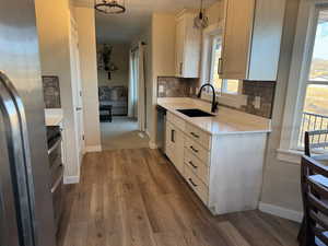 Kitchen featuring hanging light fixtures, dark hardwood / wood-style floors, a healthy amount of sunlight, and sink