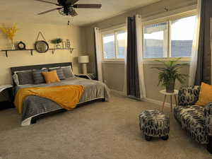 Bedroom featuring a textured ceiling, carpet, a water view, and ceiling fan