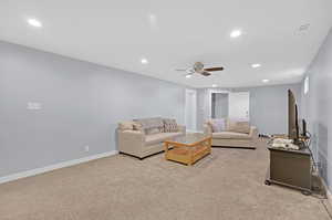 Living room featuring ceiling fan and light colored carpet