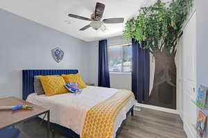 Bedroom with dark hardwood / wood-style flooring, a closet,  ceiling fan, and a Deku Tree