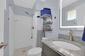 Private bathroom featuring vanity, walk in shower, and toilet, off of the main bedroom