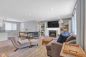 Living room with a textured ceiling, a fireplace, and hardwood / wood-style flooring