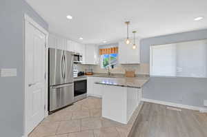 Kitchen featuring sink, white cabinets, backsplash, and stainless steel appliances