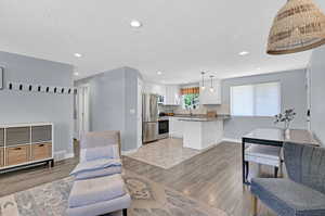 Living room featuring light wood-type flooring and a lot of natural lighting.