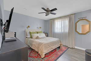 Main bedroom featuring ceiling fan and hardwood / wood-style floors, and a private bathroom.