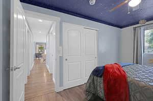 Bedroom featuring ceiling fan, hardwood / wood-style floors, and a closet