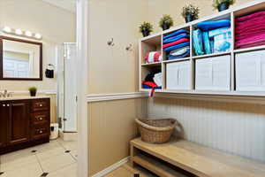 Bathroom located in the back of the garage with vanity, walk in shower, and tile patterned flooring