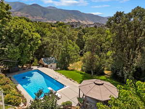 View of pool featuring a patio area, a lawn, a mountain view, and a gazebo