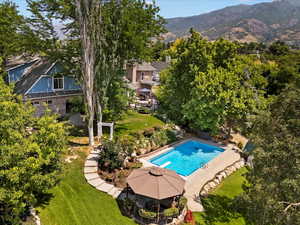 View of swimming pool featuring a lawn and a mountain view