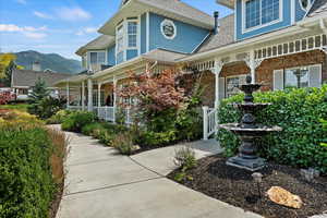 View of side of home featuring a mountain view and a porch