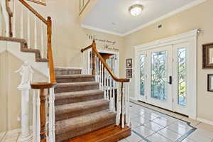 Entryway with crown molding and tile patterned flooring