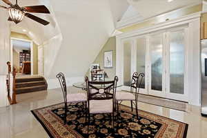 Dining area with ornamental molding, ceiling fan, vaulted ceiling, and light tile patterned floors