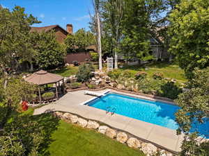 View of swimming pool with a patio, a gazebo, a yard, and a diving board