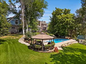 View of swimming pool featuring a gazebo and a lawn