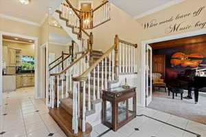 Stairs with ornamental molding and light tile patterned flooring