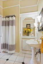 Bathroom featuring tile patterned floors and crown molding