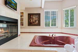 Interior space with a tiled fireplace, built in shelves, and tile counters