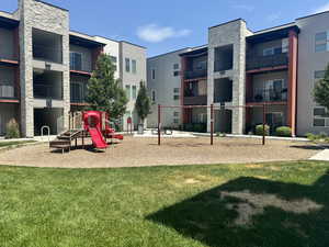 View of home's community with a playground and a lawn