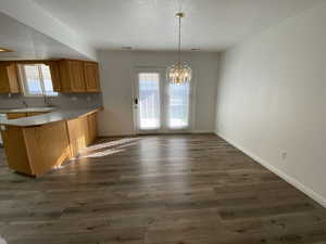 Kitchen featuring hanging light fixtures, dark hardwood / wood-style flooring, and a healthy amount of sunlight