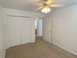 Bedroom featuring carpet, ceiling fan, and a closet