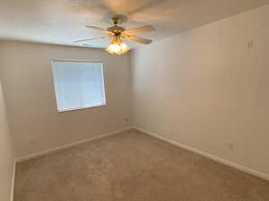 Carpeted bedroom featuring ceiling fan