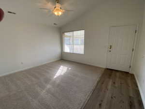 Unfurnished room featuring carpet flooring, ceiling fan, and vaulted ceiling