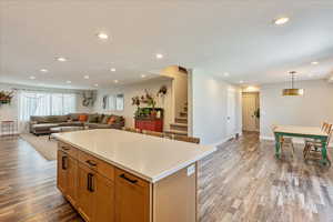 Kitchen with decorative light fixtures, a center island, and light wood-type flooring