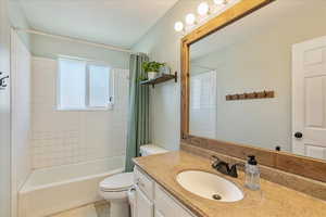 Full bathroom with tile patterned floors, vanity, toilet, and shower / bath combination with curtain