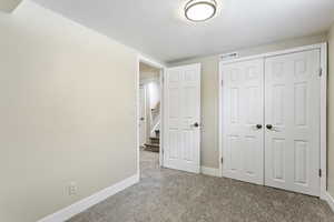 Unfurnished bedroom featuring a closet and carpet floors