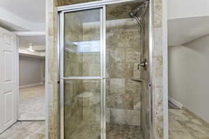 Bathroom with walk in shower and tile patterned flooring