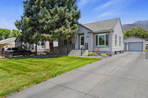 View of front of home featuring a mountain view, an outdoor structure, a garage, and a front yard