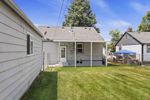 Rear view of house with a patio and a lawn