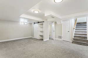 Basement featuring carpet flooring and a barn door