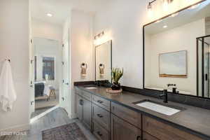 Bathroom with dual vanity and hardwood / wood-style flooring