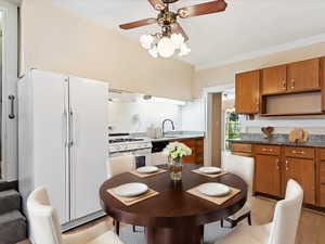 Kitchen featuring ceiling fan, light hardwood / wood-style flooring, white appliances, and custom range hood