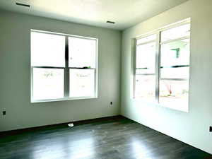 Spare room with plenty of natural light, dark hardwood / wood-style floors, and a textured ceiling