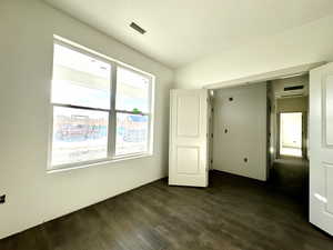 Unfurnished bedroom with dark wood-type flooring