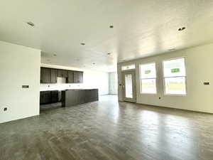 Unfurnished living room featuring a textured ceiling and wood-type flooring