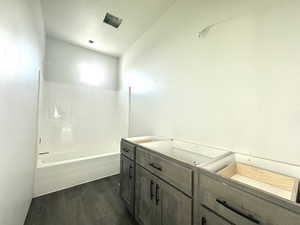 Bathroom featuring shower / bath combination, vanity, a textured ceiling, and hardwood / wood-style flooring