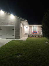 View of front facade with a garage and a yard