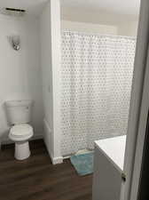 Bathroom featuring vanity, hardwood / wood-style flooring, and toilet