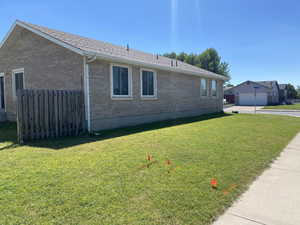 View of property exterior with a garage and a lawn